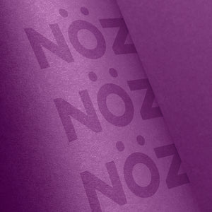 A close-up of a purple stick of Nöz sunscreen, the best reef safe, zinc oxide SPF for your face, on a purple background 