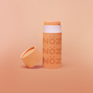 A single orange stick of Nöz sunscreen, the best reef safe, zinc oxide SPF for your face, with its cap off